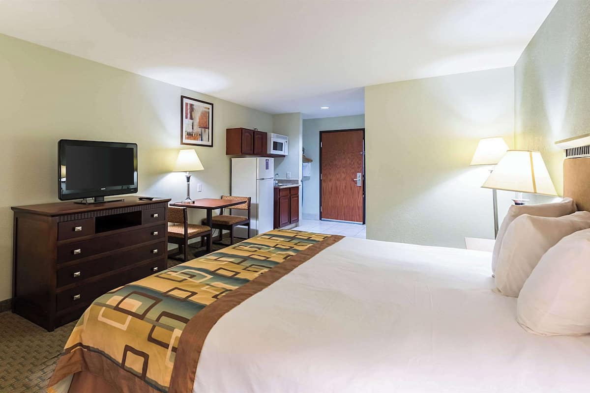 Une chambre d’hôtel équipée d’un lit, d’un bureau, d’une télévision, d’un four à micro-ondes et d’un réfrigérateur.