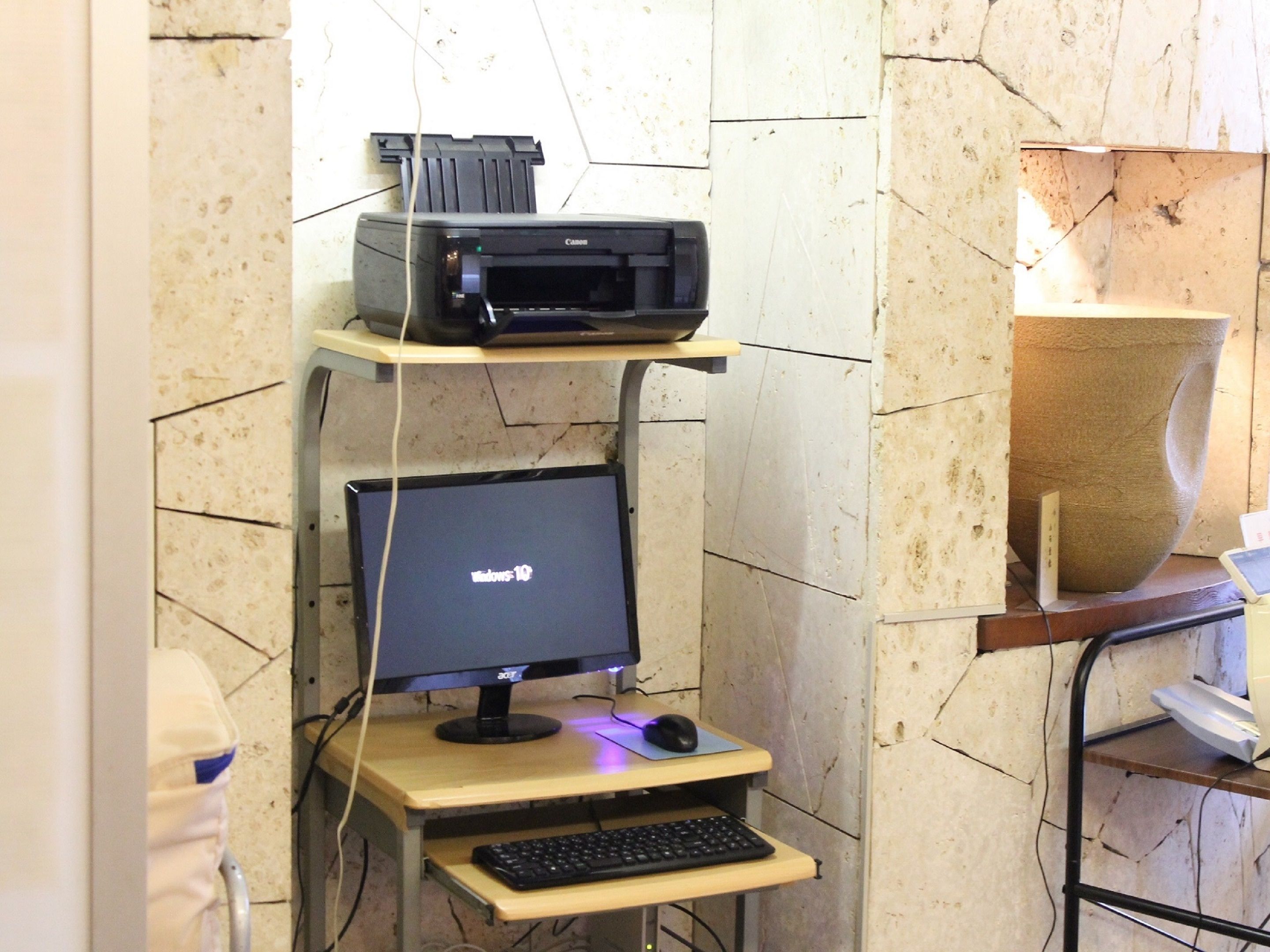 A computer desk with a monitor, keyboard, and mouse.