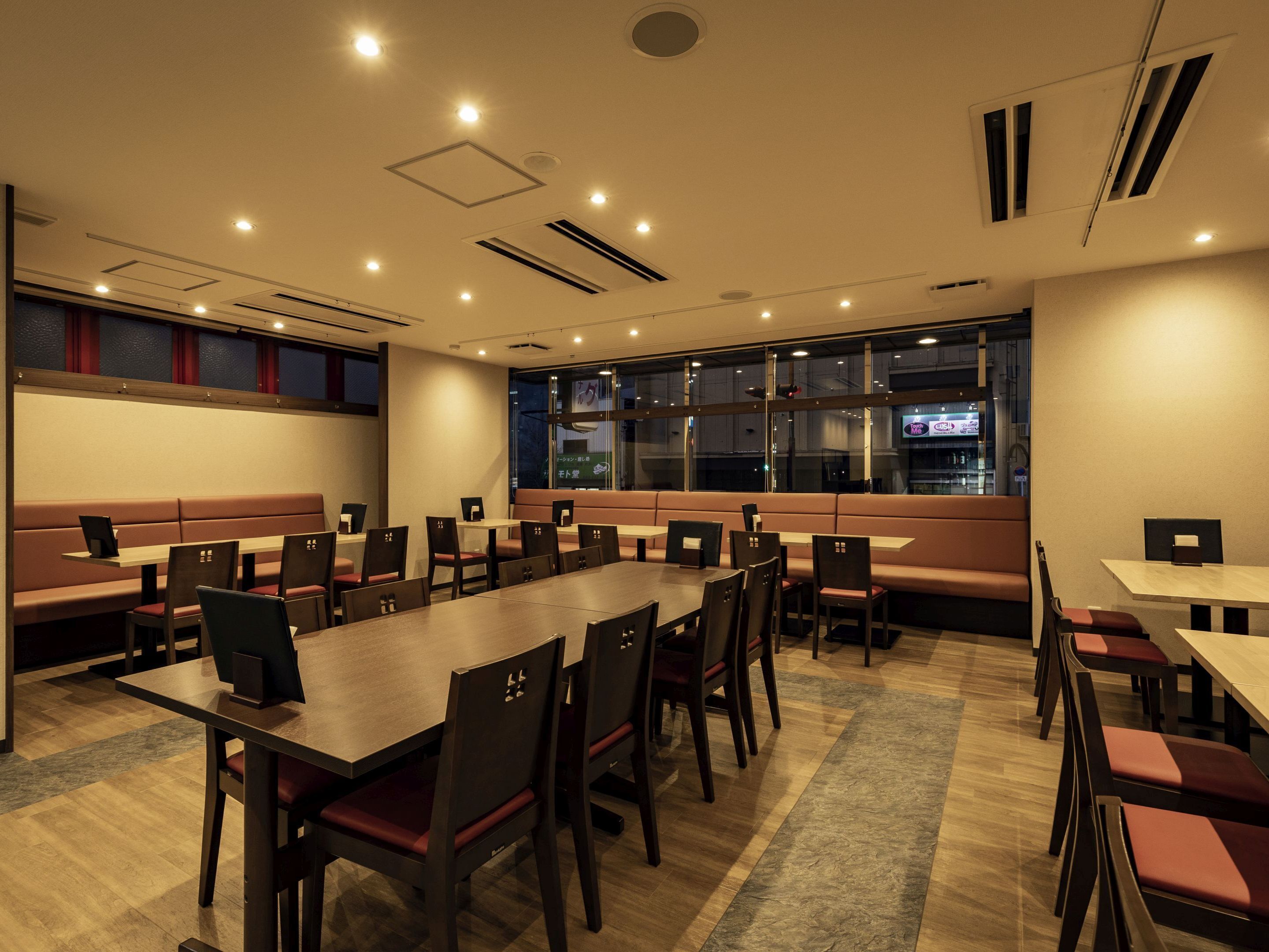A conference room with a long table, multiple chairs, and a large window.