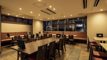 A conference room with a long table, multiple chairs, and a large window.