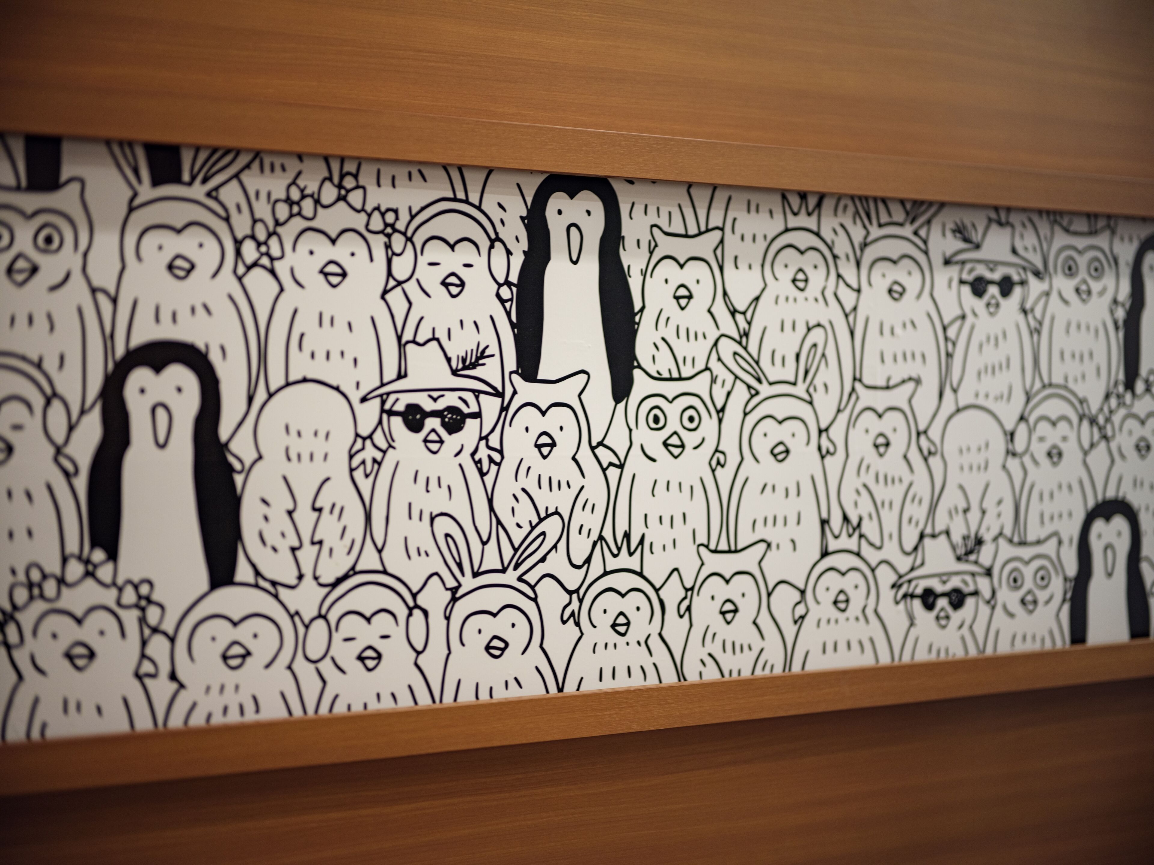 A wall with a black and white illustration of various cartoon characters.