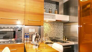 A modern kitchen with stainless steel appliances, a tiled backsplash, and a dining area with a table set for two.