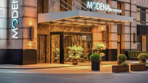 Entrada de hotel con diseño moderno, destacada por un cartel llamativo y un área de acceso cubierta.