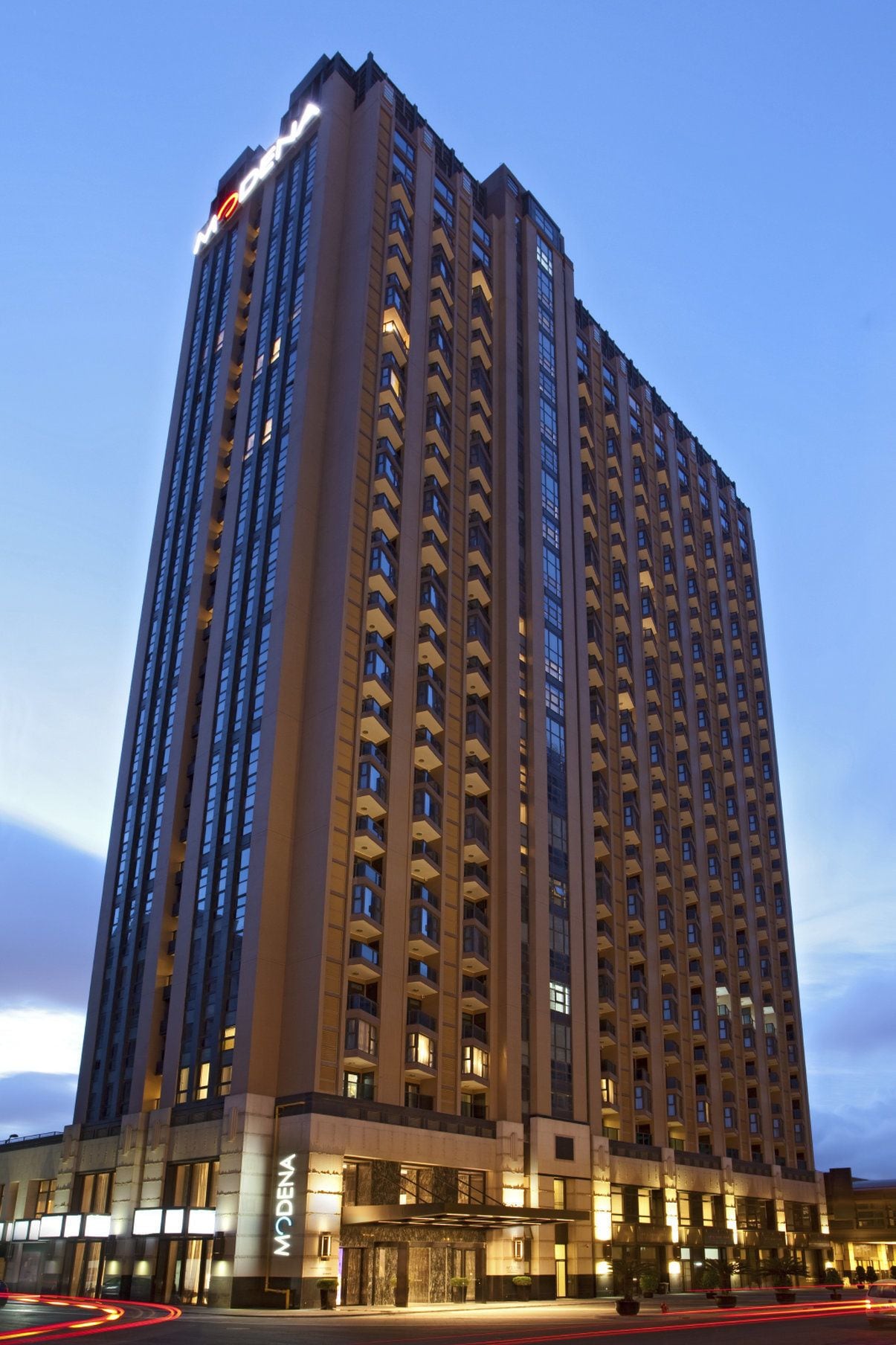 Un hotel de gran altura con diseño moderno, que cuenta con varios balcones y una entrada destacada.