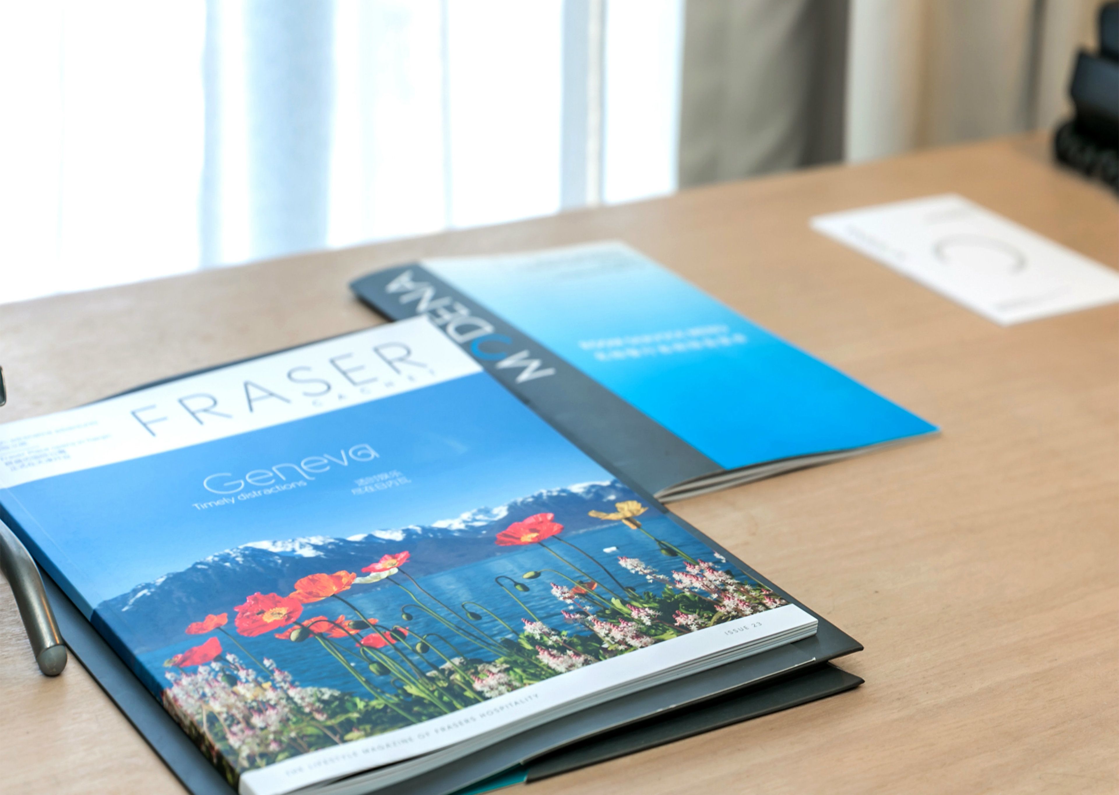 A book titled 'Fraser Geneva' on a wooden table.