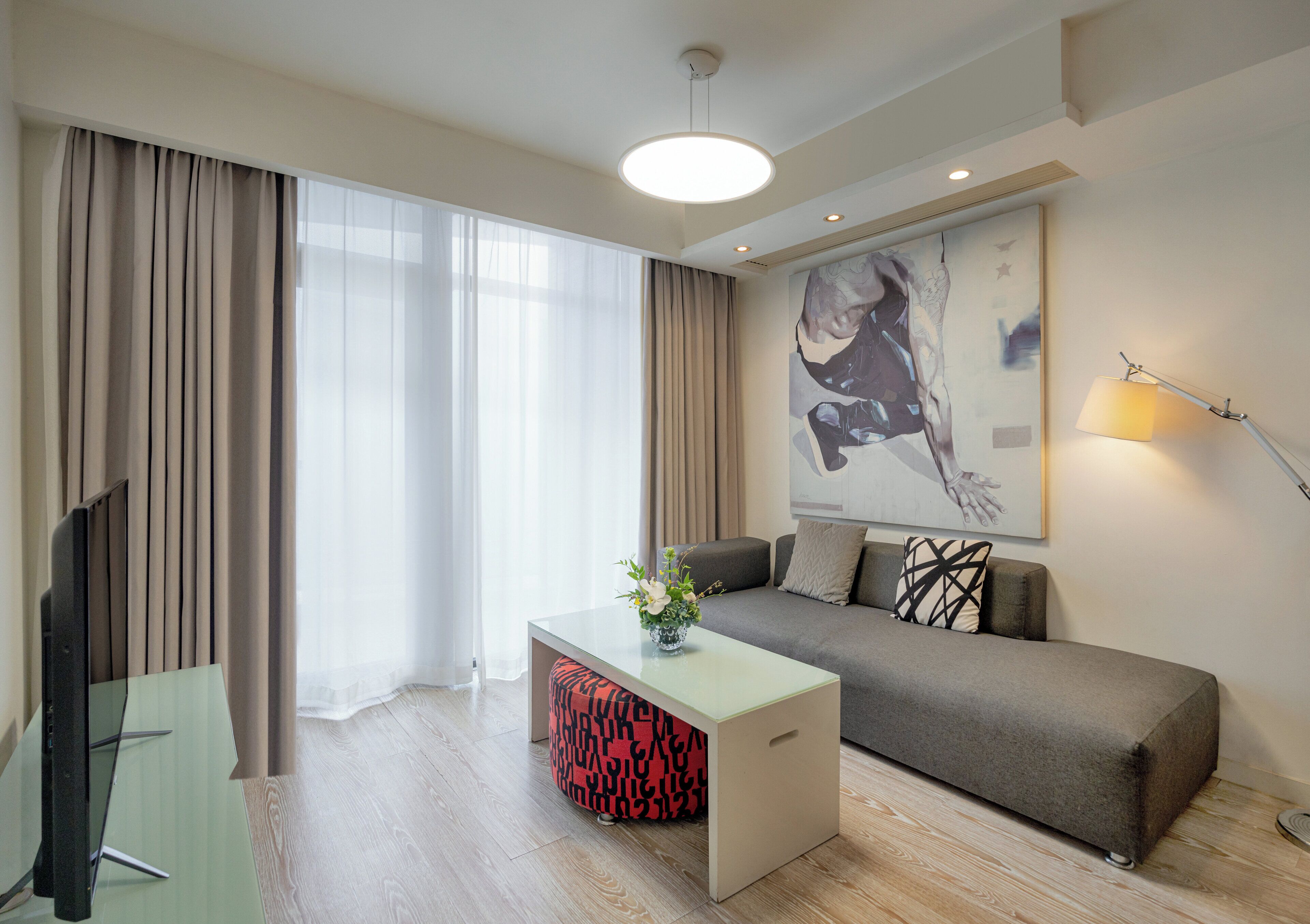 Ein modernes Wohnzimmer mit einer Couch, einem Couchtisch und einem Fernseher.
