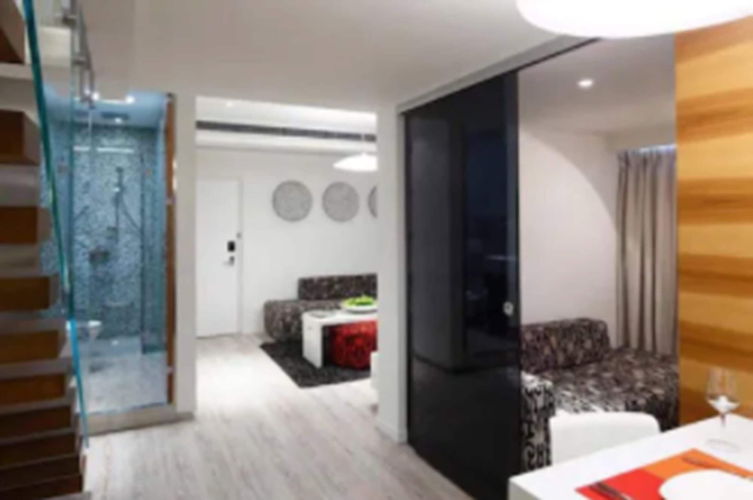 Un intérieur moderne comprenant un escalier, un coin repas et un espace de vie.