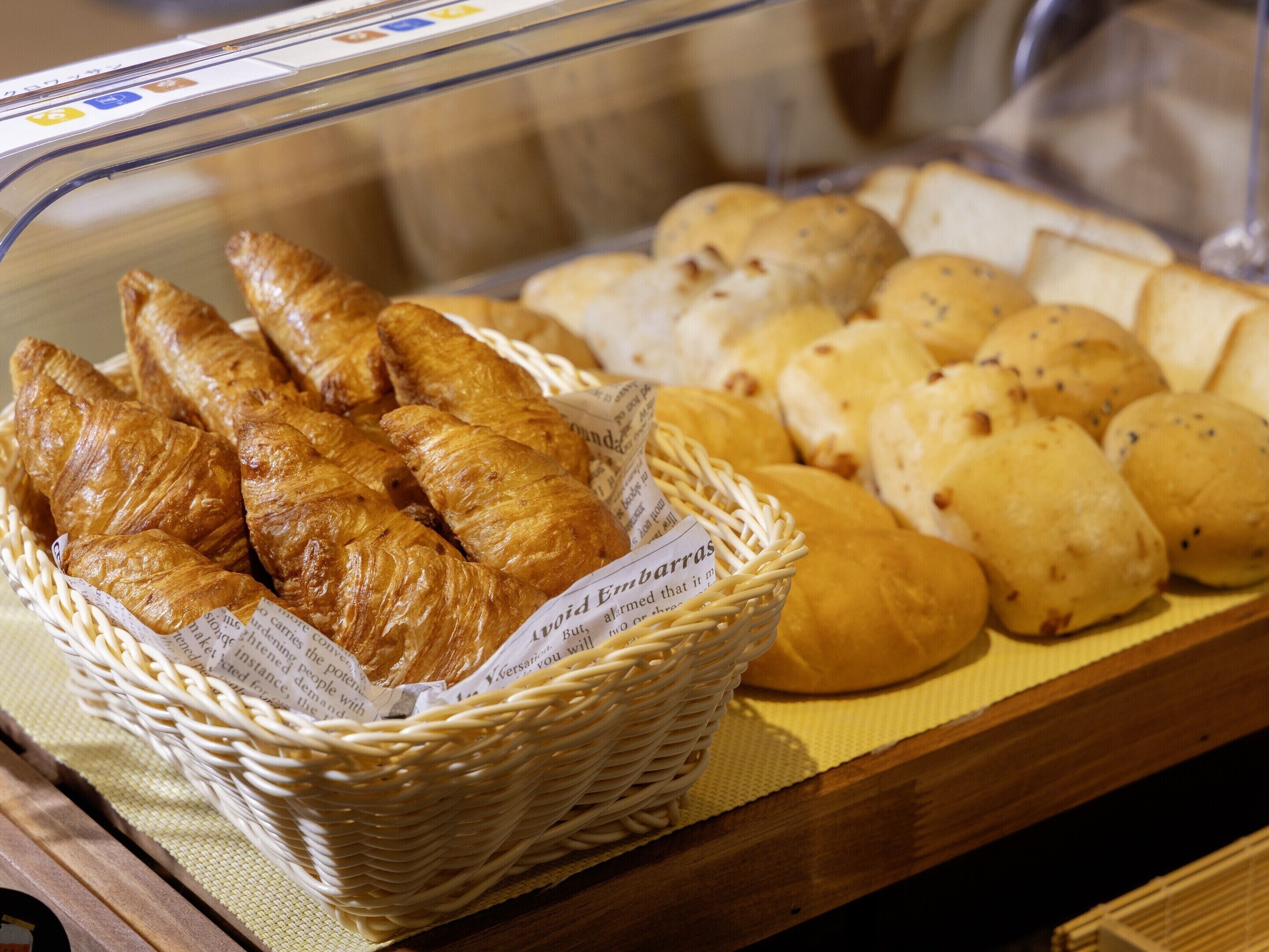 A bakery display with croissants and various bread types.