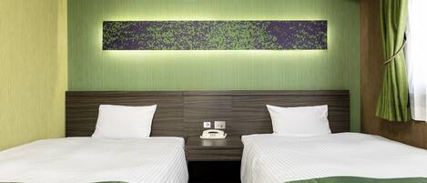 Una habitación de hotel con dos camas, una mesita de noche, un teléfono y un panel decorativo en la pared.