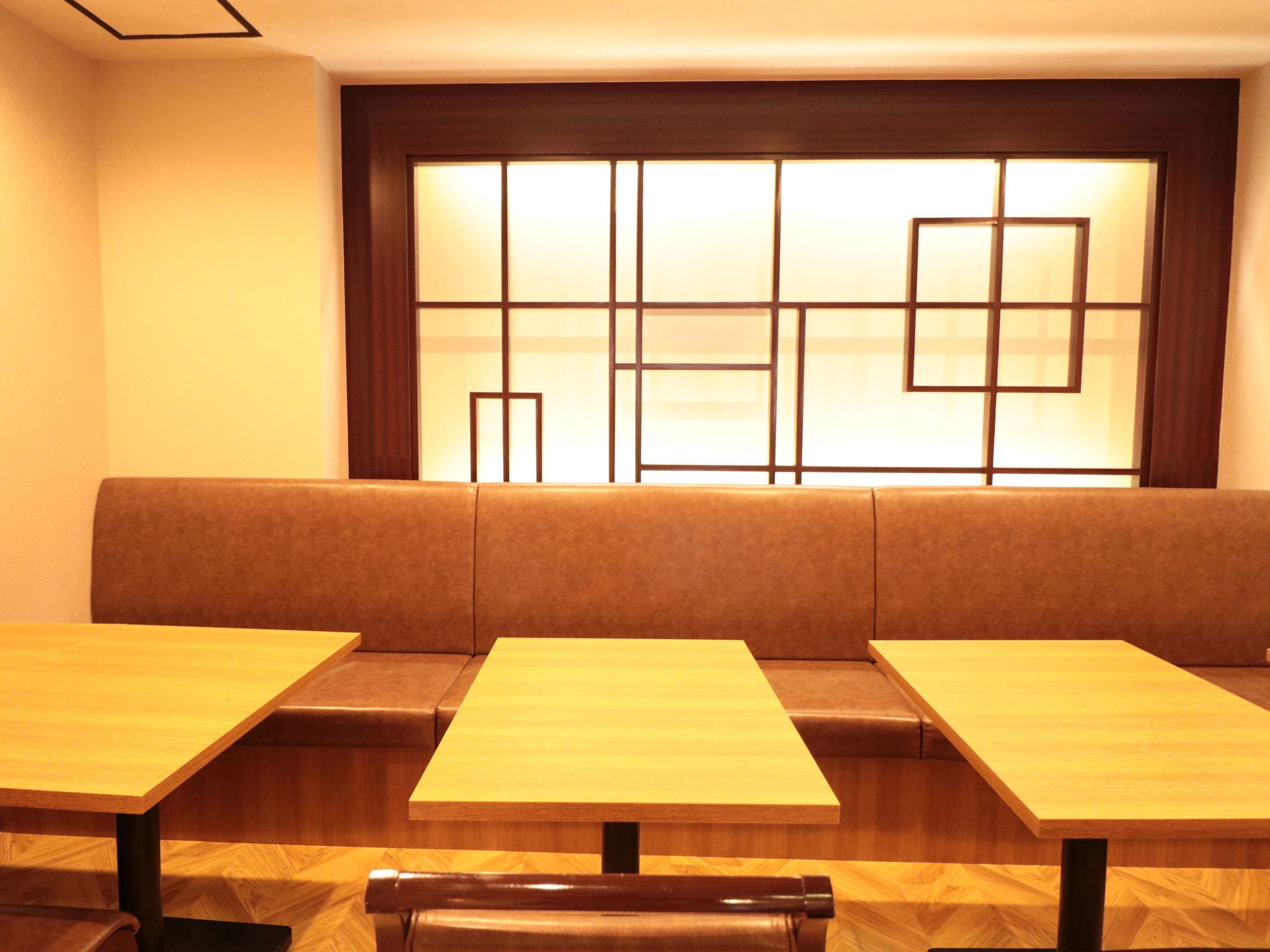 Un espace détente avec un canapé et deux tables en bois.