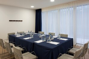 A conference room with a long table, chairs, and water bottles.