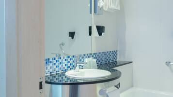 Een bad/douchecombinatie, een haardroger, een bidet, handdoeken