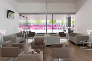 Un intérieur moderne avec un coin salon, de grandes fenêtres et une vue sur un espace extérieur.