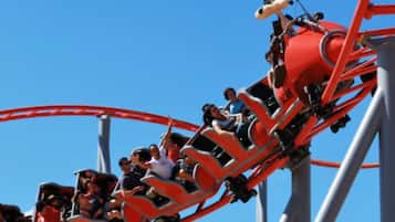 Una montaña rusa en movimiento con pasajeros sentados en filas.