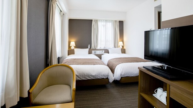 A hotel room with two beds, a TV, a chair, and a shelf with cups. - KOKO STAY Hitachi (Hitachi)