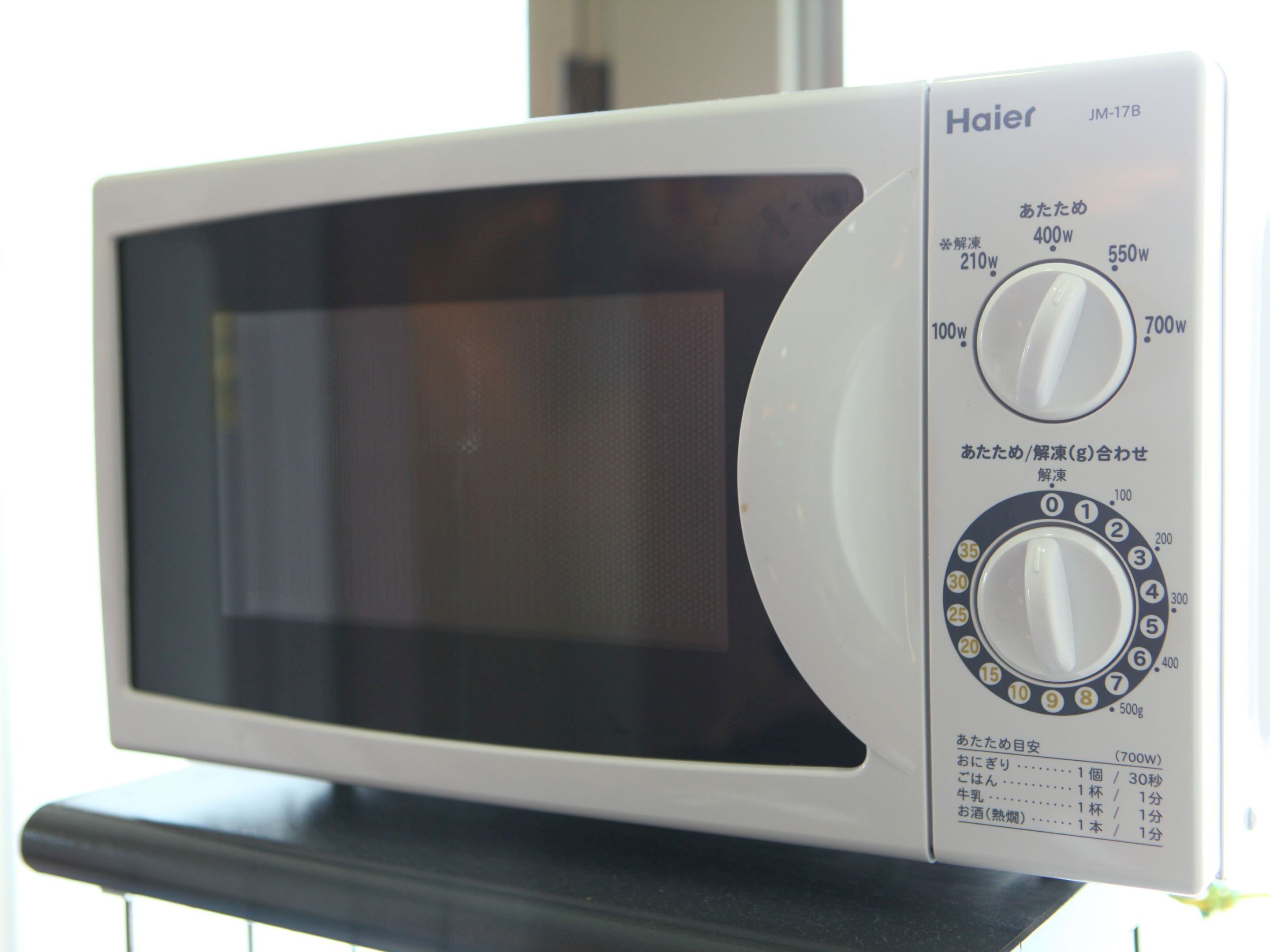 A Haier microwave oven with a digital display, a power dial, and a timer dial.