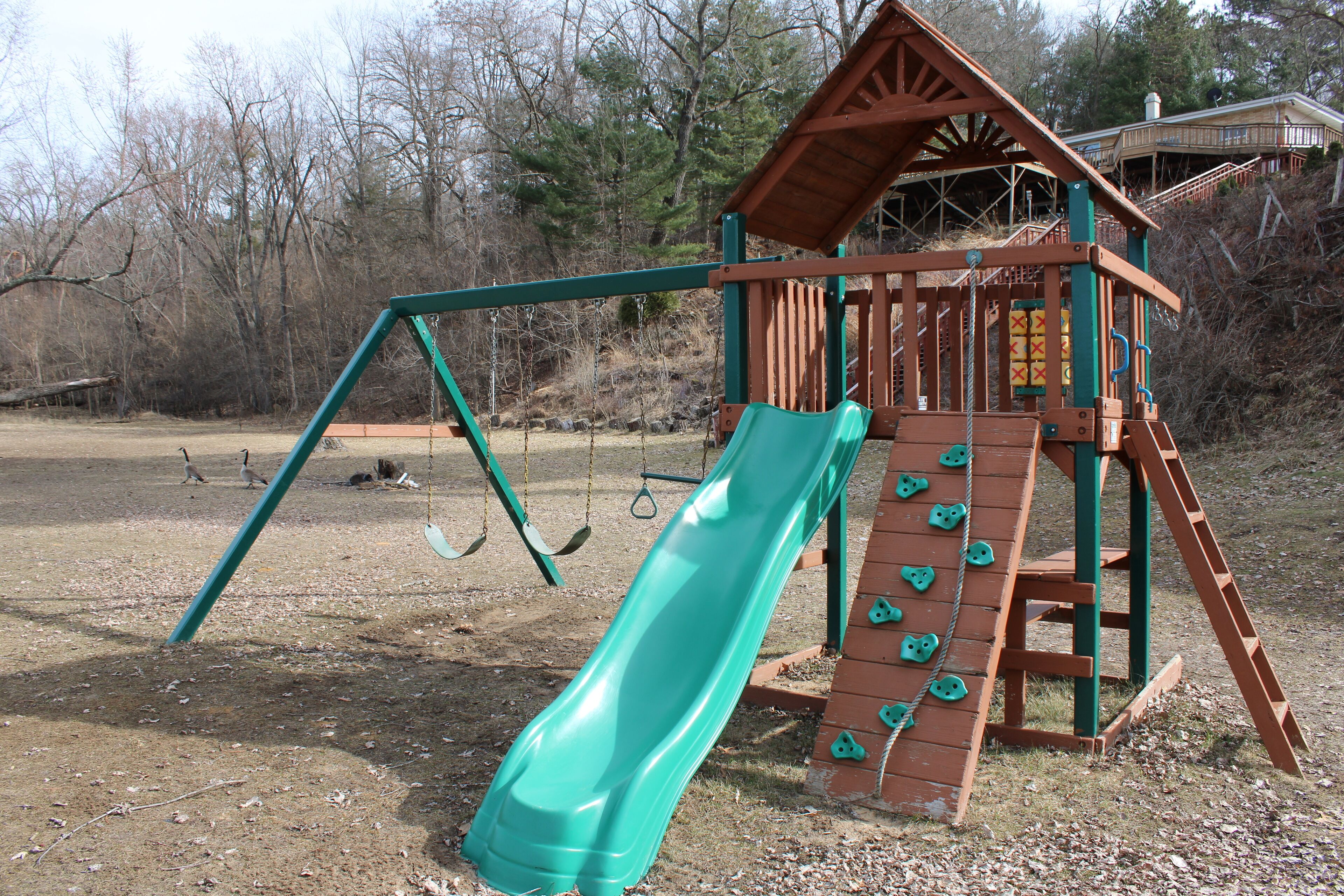 A playground with a slide and swings.