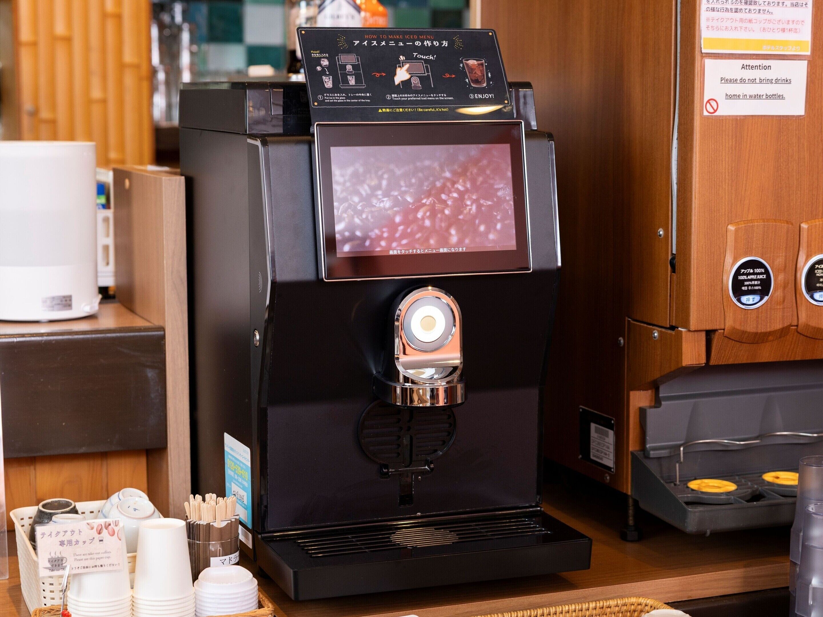 A coffee machine with a digital display, a coffee maker, and a waffle maker on a counter.