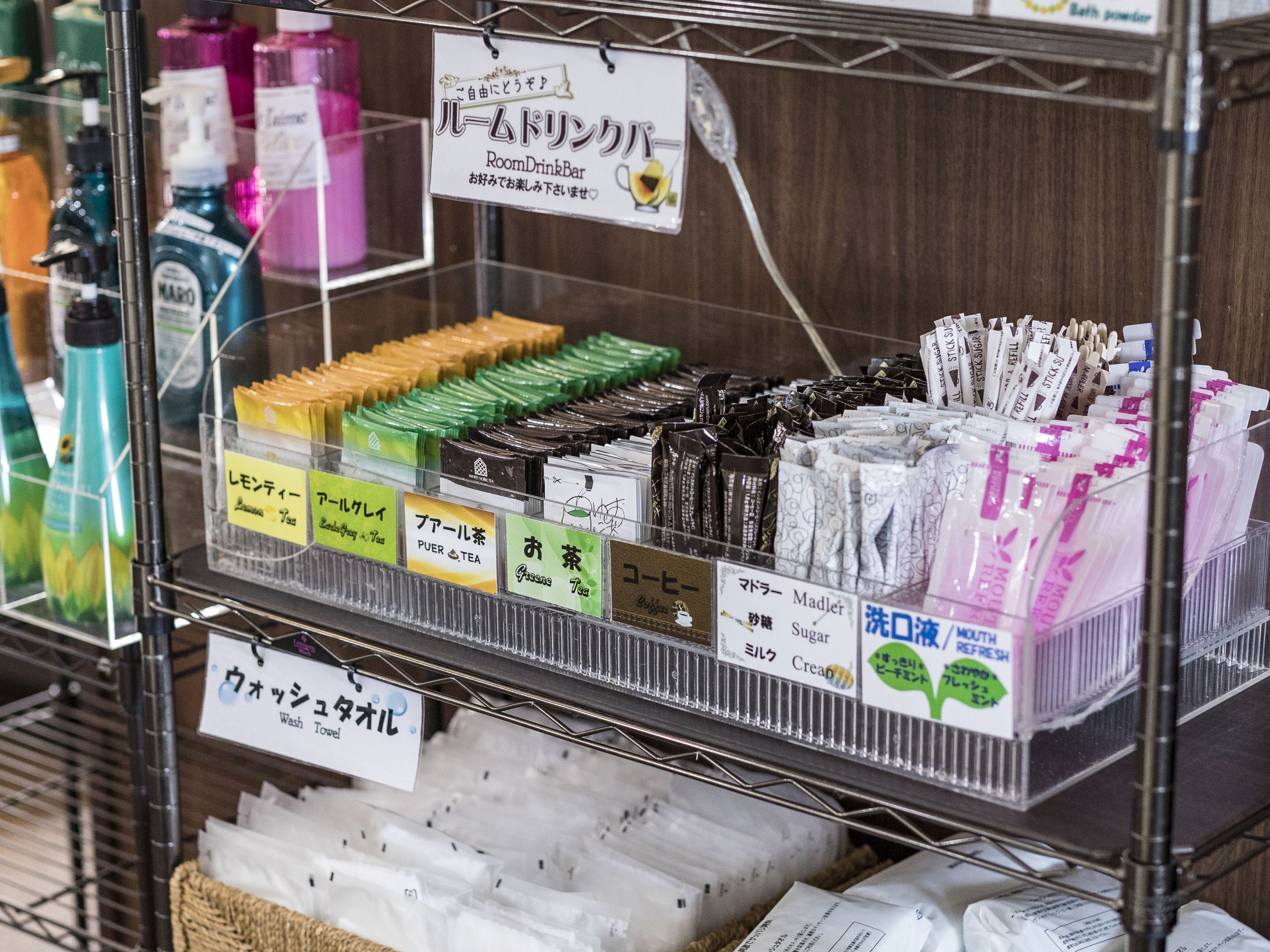 Un estante repleto de artículos de tocador y productos envasados, como té y productos de cuidado personal.