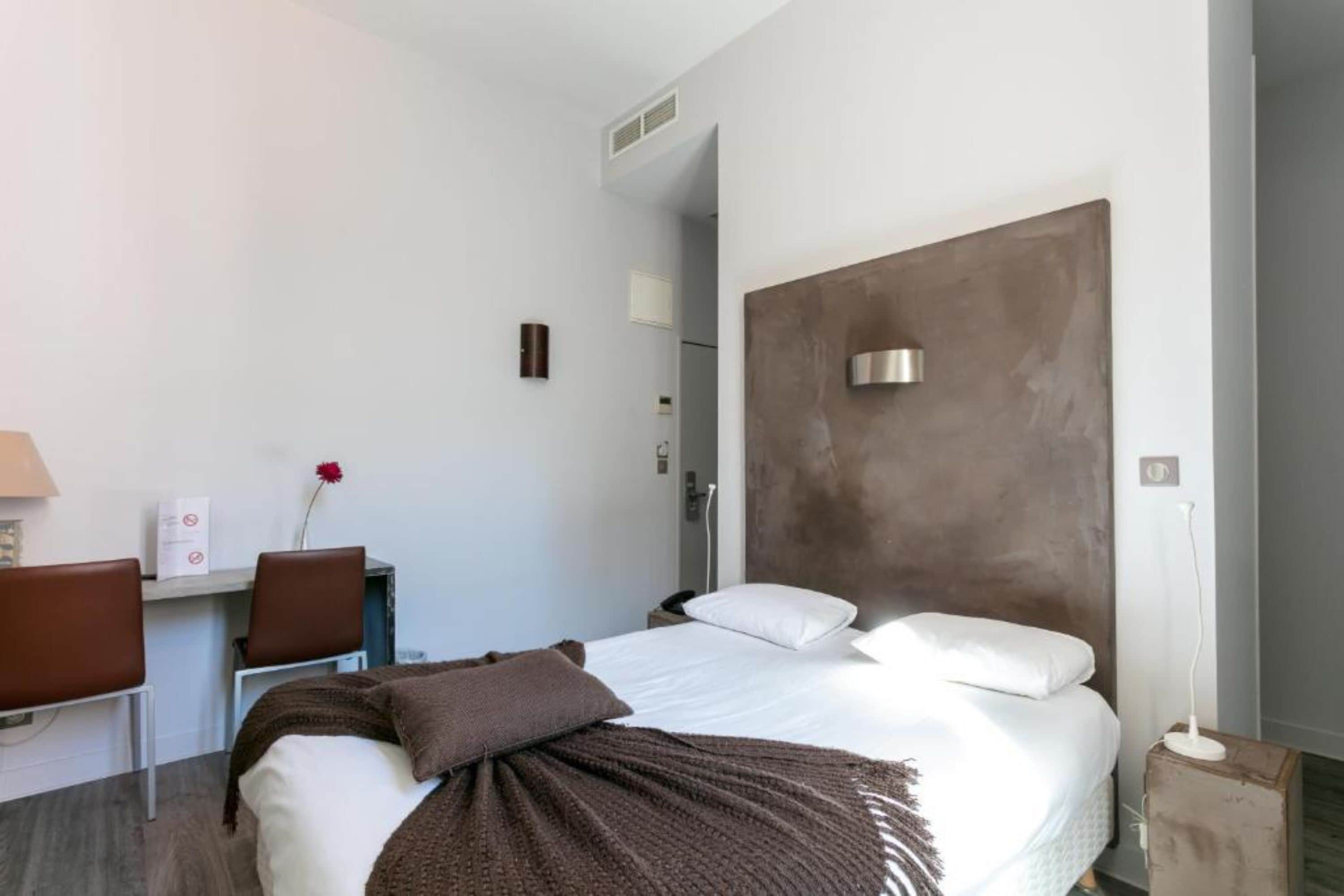 Una habitación de hotel moderna con una cama, un escritorio y una silla.
