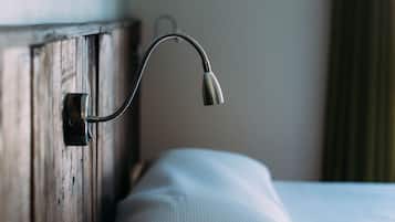 A bed with a wooden headboard and a metal lamp attached to it.