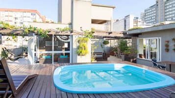 Una piscina al aire libre, sillones reclinables de piscina