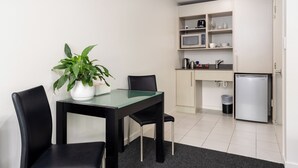 A compact kitchen with a microwave, kettle, and a small refrigerator. - Salerno Motel Apartments (Christchurch)