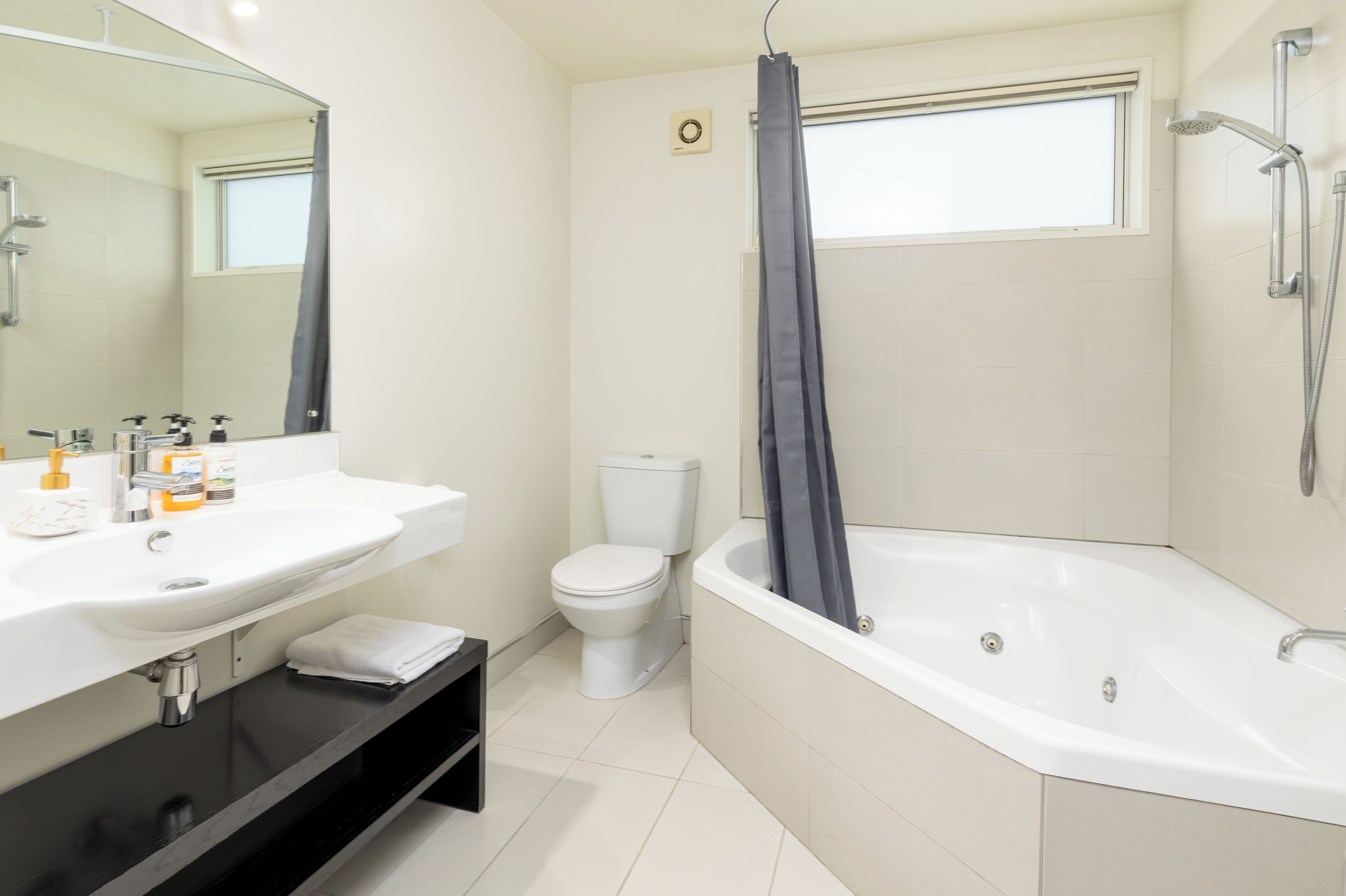 A modern bathroom with a white sink, toilet, and bathtub.