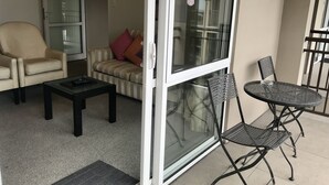 Un salon avec un canapé, un fauteuil et une petite table.