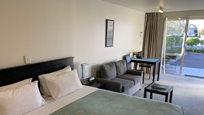 Une chambre d’hôtel avec un grand lit, un canapé, une petite table et une vue sur l’extérieur.