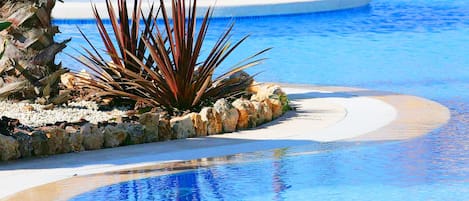 Alberca techada, alberca al aire libre y sombrillas en la alberca