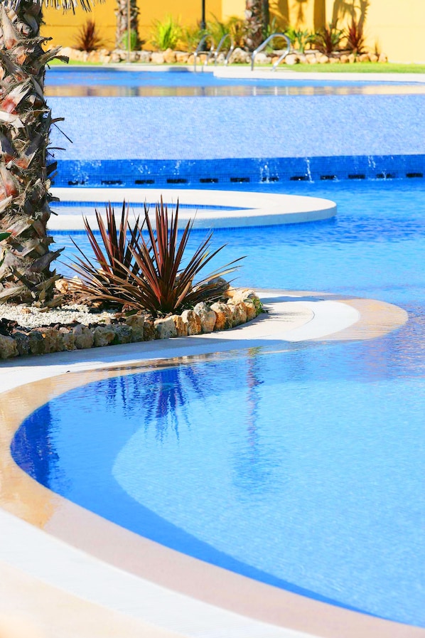 Piscine couverte, piscine extérieure, parasols de plage, chaises longues