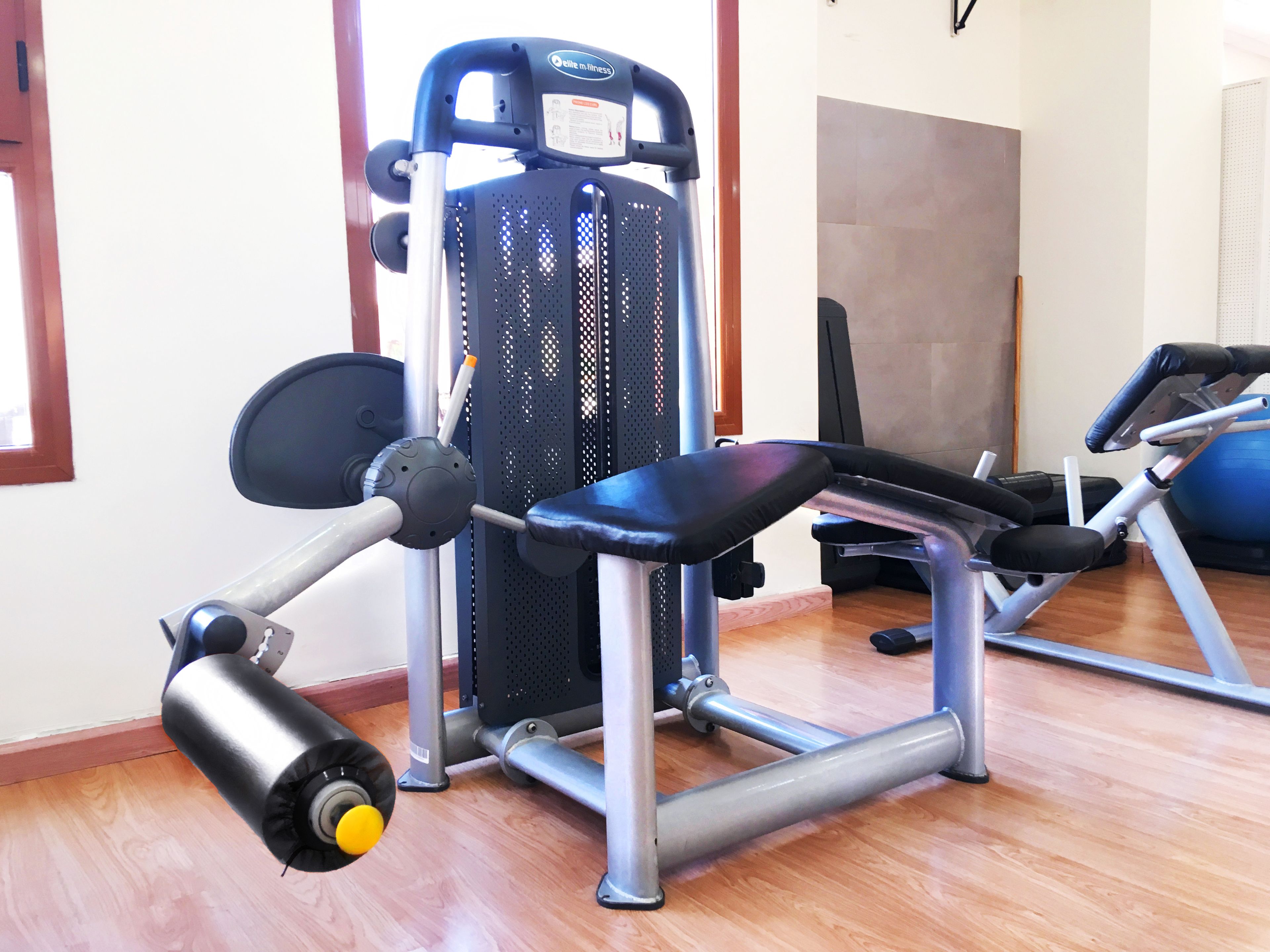 A gym with exercise equipment, including a bench and a weight machine.