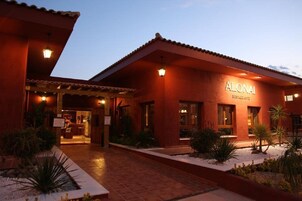 Un edificio con un letrero que dice 'ALONAI RESTAURANTE' al anochecer.