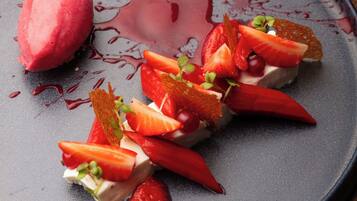 Un piattino con gelato, fragole e salsa.