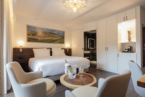 Ein Hotelzimmer mit einem großen Bett, zwei Nachttischen, einem Holztisch und einem Bild an der Wand.