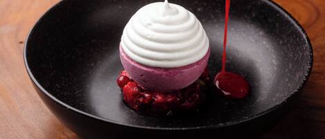 Ein Dessert mit mehrschichtiger Struktur in einer schwarzen Schüssel.