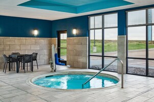 Una piscina interior con zona de estar y vistas al exterior.