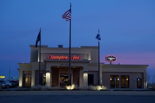 Un hotel Hampton Inn bajo un cielo despejado y con banderas.
