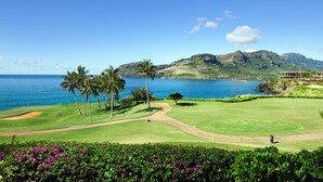 Un campo de golf con vistas al océano y las montañas.