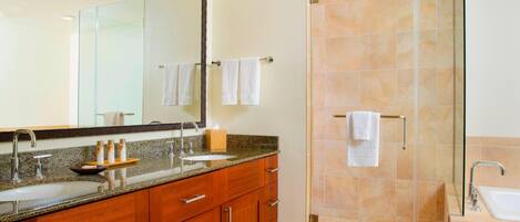 A modern bathroom with a glass-enclosed shower, a double sink vanity, and a large mirror.
