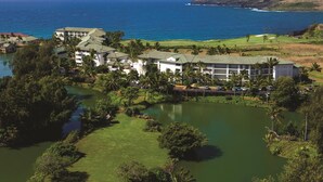 Un resort con varias construcciones, un campo de golf y una masa de agua.