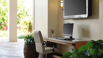 Ein moderner Arbeitsplatz mit Schreibtisch, Stuhl, Computer und großem Bildschirm.