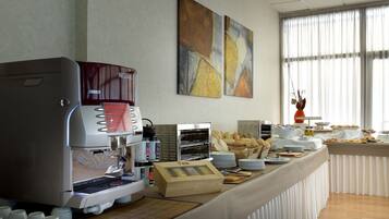 Een buffetopstelling met een koffieapparaat, brood en diverse etenswaren.