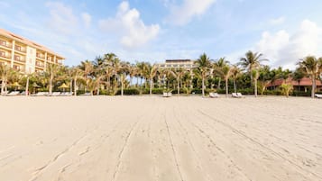 Playa privada, arena blanca, sillas reclinables de playa, sombrillas