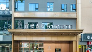 Entrada de un hotel con un cartel que dice "ECHIC HOTEL".