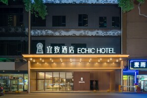 Un hotel con fachada moderna, destacando un letrero con el nombre 'ECHIC HOTEL'.