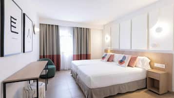 Una habitación de hotel moderna con una cama, mesita de noche y un escritorio con silla.