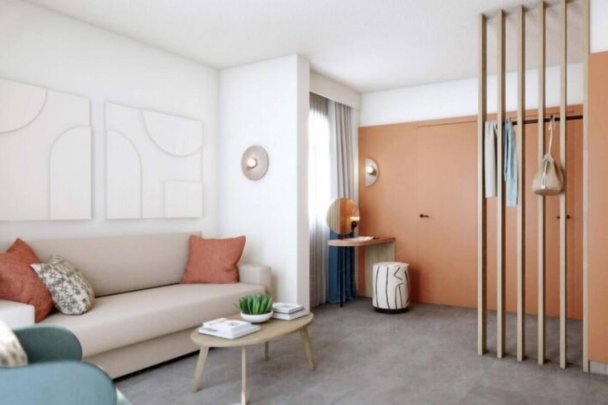 Un salon moderne avec un canapé, une table basse et une vue sur un placard doté de portes coulissantes.