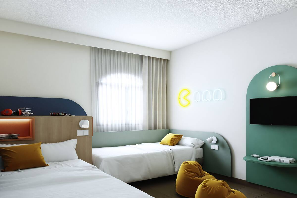 Une chambre d’hôtel avec deux lits, une télévision, une lampe et un panneau lumineux au néon.